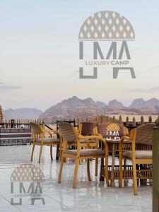 a group of wooden chairs and tables on a roof at Lma Luxury Camp in Wadi Rum