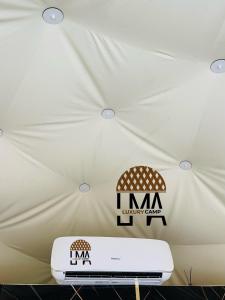 a white tent with a sign on the ceiling at Lma Luxury Camp in Wadi Rum
