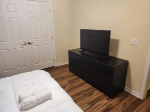 um quarto com uma cama e uma televisão numa cómoda em Spacious and comfortable Villa 4BD/2BA (10 sleeps) em Galveston