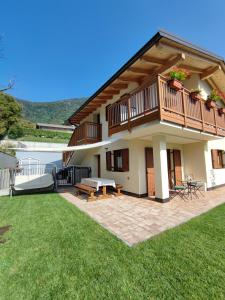 een huis met een terras en een patio bij Il Riccio del Castagno in Novaledo