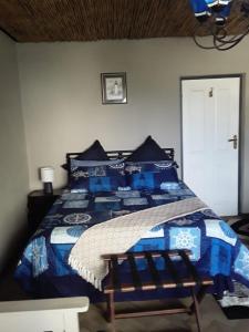 a bedroom with a blue bed with blue pillows at Beach Haven Sea Views, Fritzandi, Strand, Cape Town in Cape Town
