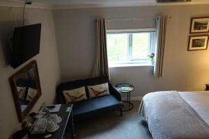 a bedroom with a bed and a chair and a window at Lundie View B & B in Invergarry