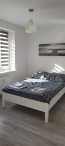 Una cama en una habitación blanca con azeb en Apartament nad jeziorem, en Olsztyn