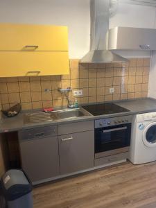 uma cozinha com um lavatório e um fogão em Ferienwohnung Siegen Eiserfeld 5 em Siegen
