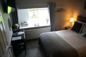 een slaapkamer met een bed en een raam bij Lundie View B & B in Invergarry
