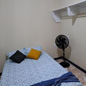 Schlafzimmer mit einem Bett und einem Ventilator in der Unterkunft Casa nova e ventilada, varanda em Praia de Jacaraípe ES in Serra