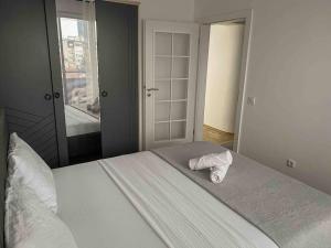 ein Schlafzimmer mit einem Bett und einem Handtuch darauf in der Unterkunft Hyper Centre Apartment Prishtina in Pristina