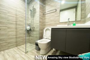 een badkamer met een toilet en een glazen douche bij Century Spire Makati in Manilla