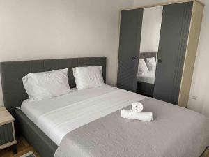 ein Schlafzimmer mit einem Bett mit einer Rolle Handtücher drauf in der Unterkunft Hyper Centre Apartment Prishtina in Pristina