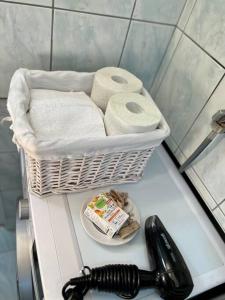ein Waschbecken mit einem Korb mit Handtüchern und einem Telefon in der Unterkunft Hyper Centre Apartment Prishtina in Pristina