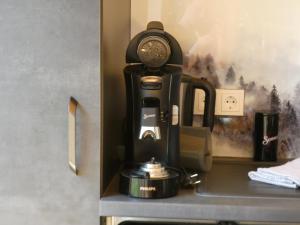 Stylische Fewo in Bestlage in neugebautem Holzhaus mit Oberstaufen Plus في اوبرستوفن: آلة صنع القهوة على رأس رف