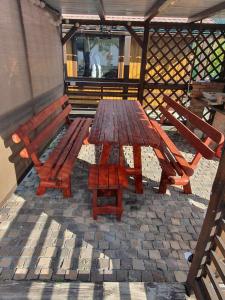 a wooden picnic table and bench on a patio at Aqua Garden in Miercurea-Ciuc