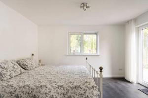 um quarto branco com uma cama e 2 janelas em Modern Luxury villa em Zeewolde