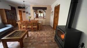 a living room with a wood stove and a table at Casa rural Molino Jaraiz in Yeste