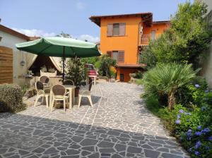 a patio with a table and an umbrella and chairs at Bbsupottai in Càbras