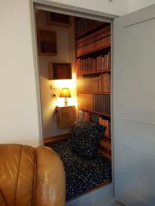 a room with a couch and a book shelf with books at Maison centre-ville calme avec jardin in Lons-le-Saunier