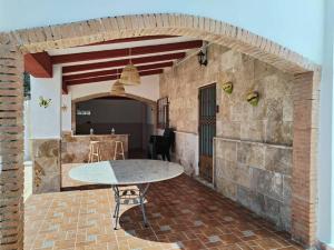 eine Außenterrasse mit einem Tisch und einer Ziegelwand in der Unterkunft Villa La Hojilla relax o trabajo in Cantoria