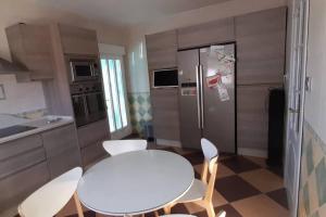 eine Küche mit einem weißen Tisch und Stühlen sowie einem Kühlschrank in der Unterkunft Villa La Hojilla relax o trabajo in Cantoria