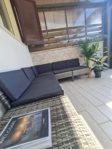 a patio with a bench and a book on a rug at Il Nido Casa indipendente a Fiumicino Self check in in Fiumicino
