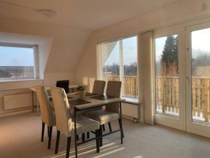 jadalnia ze stołem, krzesłami i oknami w obiekcie Apartment near nature w mieście Birkerød