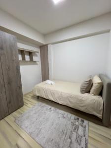 La Maison Apartment Skopje في إسكوبية: غرفة نوم بسرير وجدار ابيض