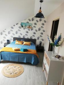 Un dormitorio con una cama azul y una pared en Gîte du capitaine, en Maranville