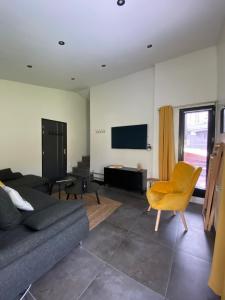 uma sala de estar com um sofá e uma televisão em Les Marmottes em Tignes