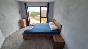 Una cama pequeña en una habitación con ventana. en Beach apartments Ema, en Kranevo