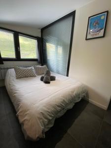 a bedroom with a large white bed with windows at Les Marmottes in Tignes