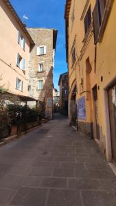 une rue vide dans une ruelle entre deux bâtiments dans l'établissement Monolocale Studio Flat, à Pérouse