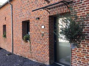 a brick building with a door and a plant at Suite Factory : gîte de charme en Avesnois in Wargnies-le-Petit