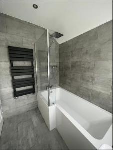 W łazience znajduje się biała wanna i prysznic. w obiekcie Mark Road Villa w Oksfordzie