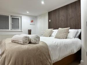 ein Schlafzimmer mit einem großen Bett mit weißer Bettwäsche und Kissen in der Unterkunft Mark Road Villa in Oxford