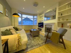 a living room with a couch and a fireplace at Mark Road Villa in Oxford