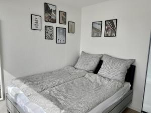 1 cama en un dormitorio con cuadros en la pared en PANORAMA - Exklusives Apartment an der Promenade mit Dachterrasse & Rheinblick en Emmerich