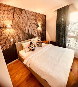 um quarto com uma cama branca com almofadas em Ryan Homes - in ApartHotel - La Défense em Courbevoie