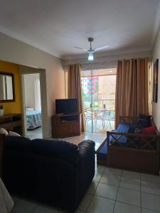 a living room with a couch and a tv at Apartamento da Martha in Ubatuba
