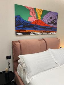 a bedroom with a bed and a painting on the wall at Le Colonne B&b in Ercolano