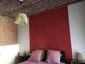 Wargnies-le-Grand的住宿－Suite Terracotta : Gîte de charme en Avesnois，一间卧室设有红色的墙壁和一张粉红色床单。