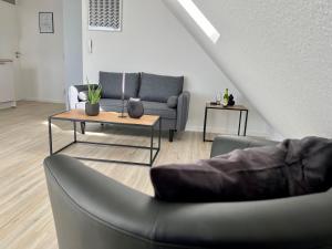 a living room with a couch and a table at PANORAMA - Exklusives Apartment an der Promenade mit Dachterrasse & Rheinblick in Emmerich
