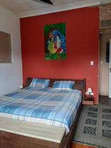 1 dormitorio con 1 cama con pared roja en Embu Manacás da Serra, en Embu
