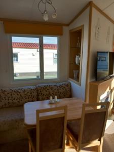 a living room with a table and a couch at Melody Brooks Caravan Park Caravan number 22 in Portknockie