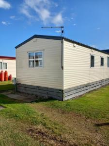 a white building with a window on the side of it at Melody Brooks Caravan Park Caravan number 22 in Portknockie