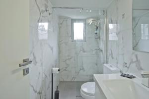 a white bathroom with a shower and a toilet at Athina in Athens