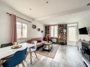 a living room with a table and a couch at Maison avec terrasse à quelques minutes de la place Morny in Deauville