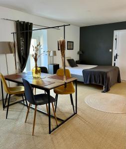 - une chambre avec un lit, une table et des chaises dans l'établissement Flor du Mont Gîte, à Pontorson