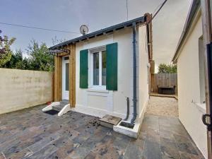 a small house with a window on a patio at Maison avec terrasse à quelques minutes de la place Morny in Deauville