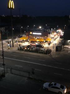 Un restaurante McDonalds con coches aparcados en un estacionamiento por la noche en Квартира по вулиці Набережна, en Vyshgorod
