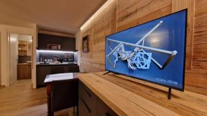 a large screen tv on a wooden wall in a room at Desirée in Morgex