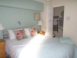 1 dormitorio con 1 cama blanca grande con almohadas en Waterside, Elmham Watermill, Norfolk, en North Elmham